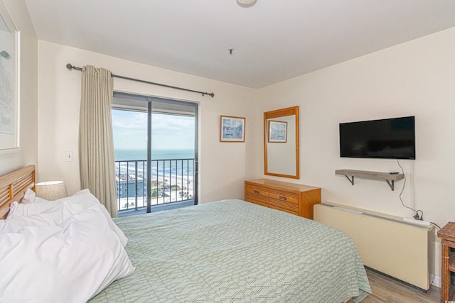 bedroom with access to exterior and wood finished floors