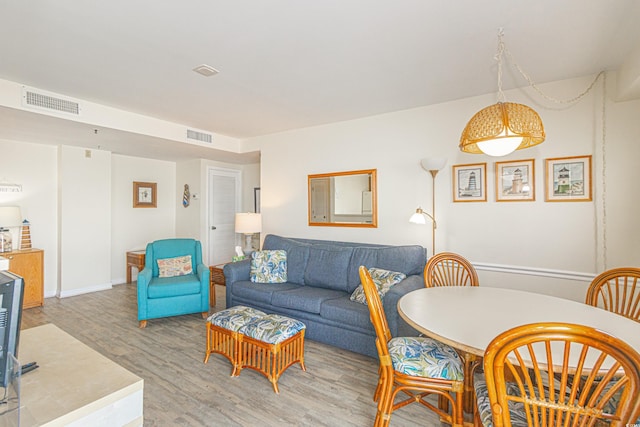 living area featuring light wood-style flooring and baseboards