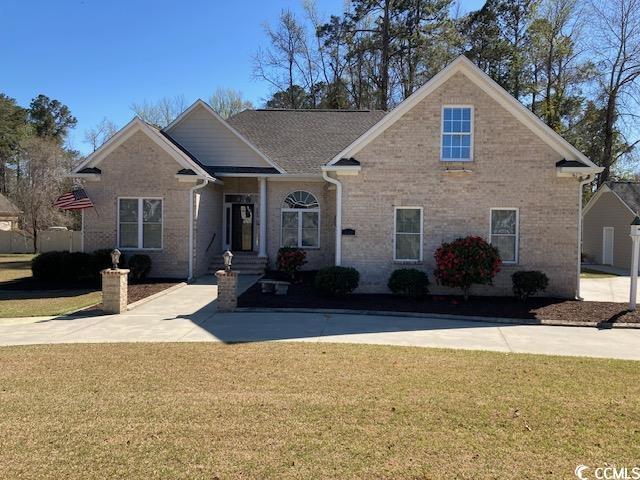 view of front of house with a front yard and brick siding