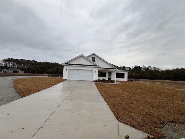 view of front facade with a front yard, concrete driveway, and an attached garage
