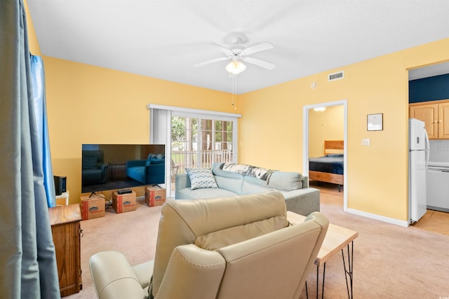 living area featuring baseboards, light carpet, a ceiling fan, and visible vents
