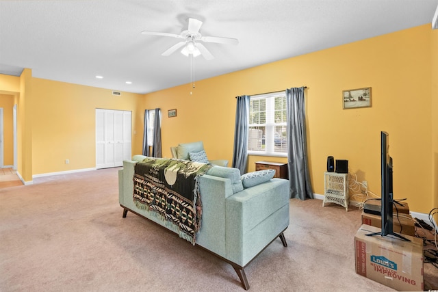 living room with baseboards, light carpet, a ceiling fan, and visible vents