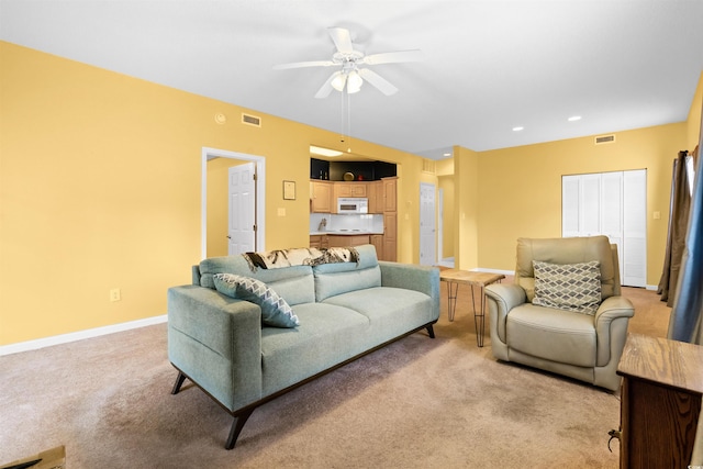 living room with visible vents, baseboards, ceiling fan, and light carpet