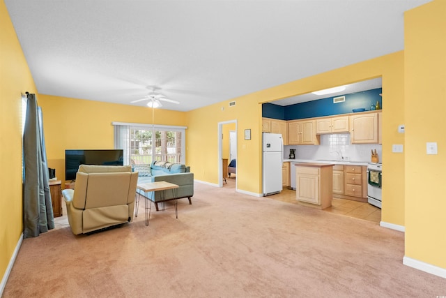 living area featuring light colored carpet, baseboards, ceiling fan, and visible vents