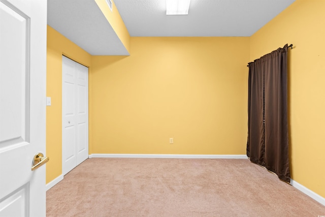 unfurnished room with baseboards, light colored carpet, and visible vents