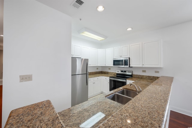 1025 World Tour Blvd Unit 101A, Myrtle Beach, SC 29579 - kitchen featuring appliances with stainless steel finishes, a sink, white cabinetry, a peninsula, and dark wood-style floors