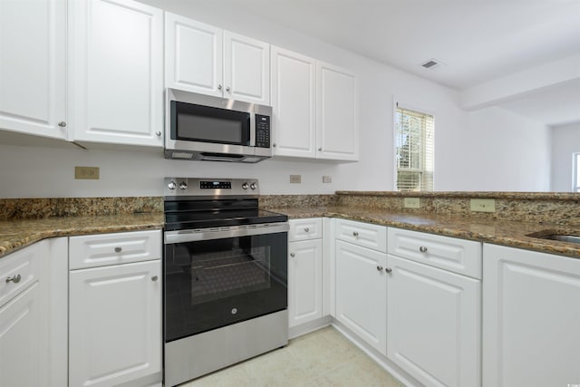1025 World Tour Blvd Unit 101A, Myrtle Beach, SC 29579 - kitchen with stainless steel appliances, white cabinetry, light tile patterned floors, and dark stone counters