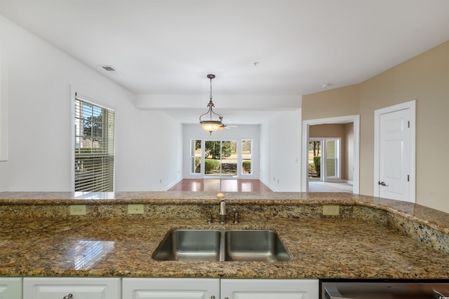 1025 World Tour Blvd Unit 101A, Myrtle Beach, SC 29579 - kitchen with a sink, dark stone counters, white cabinetry, and plenty of natural light