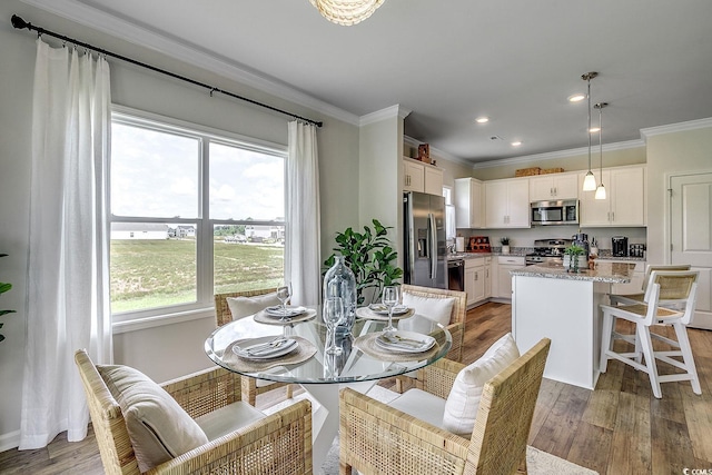dining space featuring crown molding, recessed lighting, a wealth of natural light, and light wood-style floors