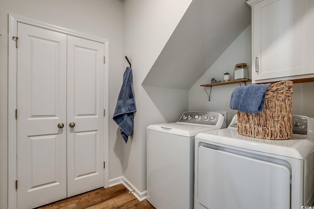 laundry room with washing machine and dryer, wood finished floors, baseboards, and cabinet space