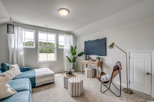 living room featuring visible vents, baseboards, carpet, and vaulted ceiling