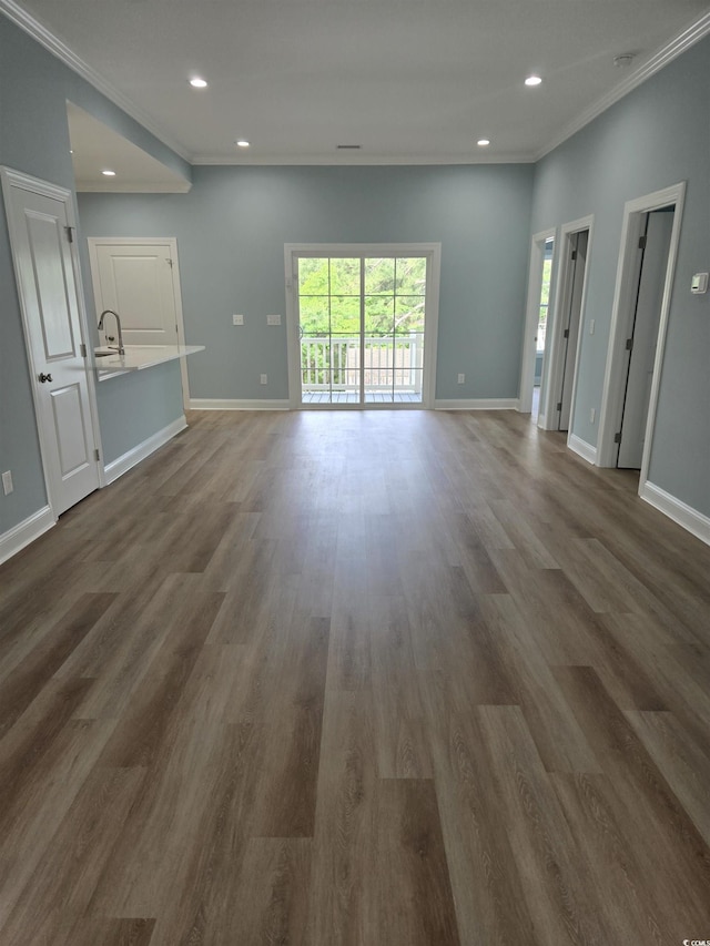 605 15th Ave S, North Myrtle Beach, SC 29582 - unfurnished living room with ornamental molding, baseboards, dark wood-style floors, recessed lighting, and a sink