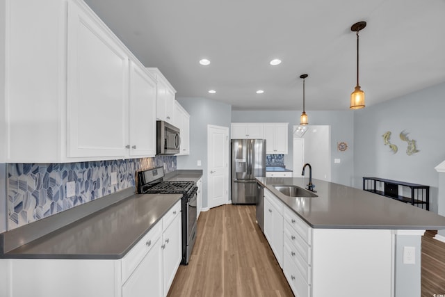 3304 Candytuft Dr, Conway, SC 29526 - kitchen with appliances with stainless steel finishes, light wood-type flooring, dark countertops, backsplash, and white cabinetry