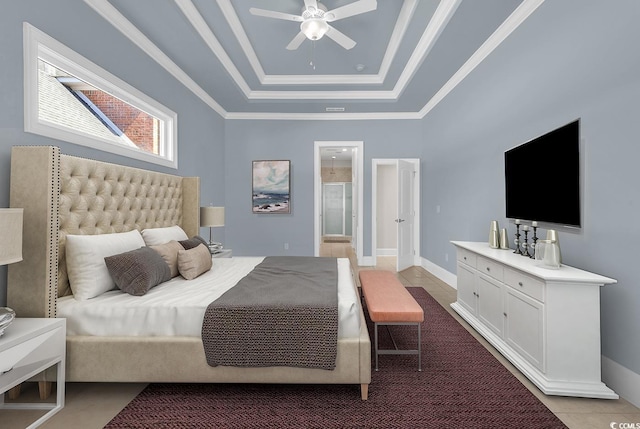 bedroom featuring light tile patterned floors, ornamental molding, ensuite bathroom, baseboards, and a tray ceiling