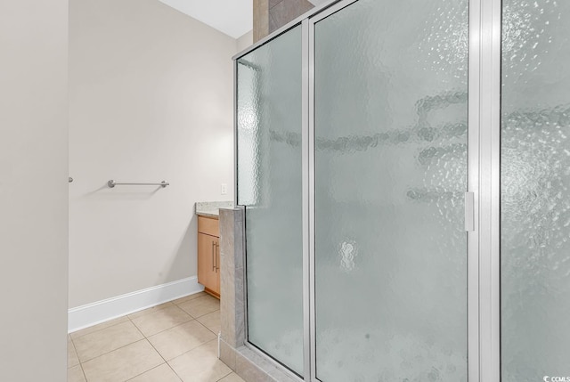 full bath featuring vanity, a shower stall, tile patterned floors, and baseboards