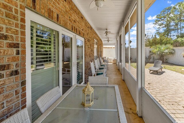 unfurnished sunroom with a ceiling fan