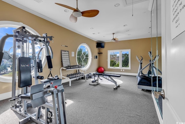 exercise room with attic access, ceiling fan, ornamental molding, and baseboards