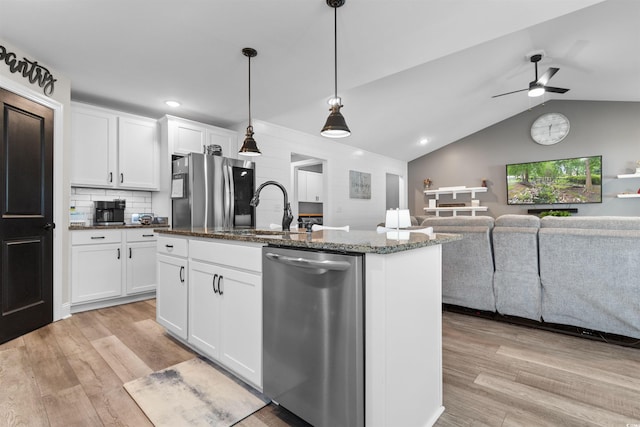 134 Winding Path Dr, Loris, SC 29569 - kitchen with appliances with stainless steel finishes, light wood finished floors, open floor plan, a sink, and dark stone counters