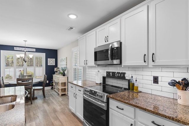 134 Winding Path Dr, Loris, SC 29569 - kitchen featuring stainless steel appliances, a chandelier, white cabinets, light wood-style floors, and tasteful backsplash