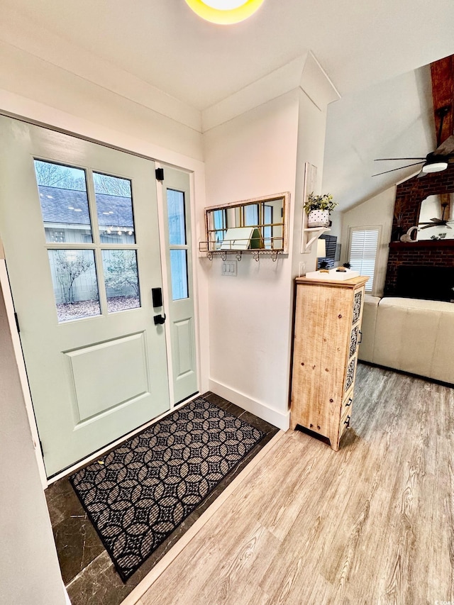 foyer entrance featuring baseboards, ceiling fan, and wood finished floors