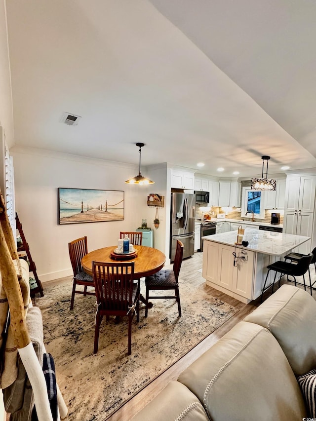 dining space with baseboards, recessed lighting, visible vents, and light wood-style floors