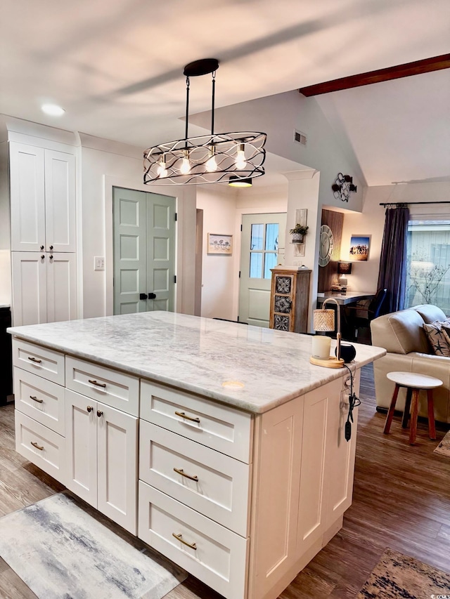 kitchen with open floor plan, vaulted ceiling, wood finished floors, and white cabinetry