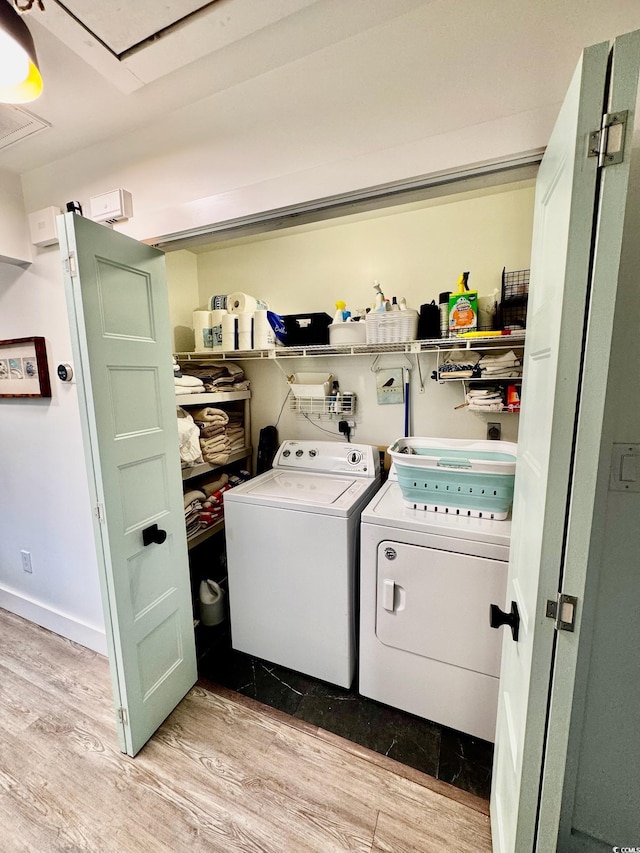 laundry area with washing machine and clothes dryer, baseboards, wood finished floors, laundry area, and attic access