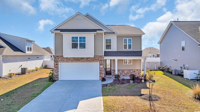 craftsman-style house featuring stone siding, concrete driveway, central AC unit, and an attached garage