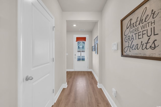 hall featuring wood finished floors, baseboards, and recessed lighting