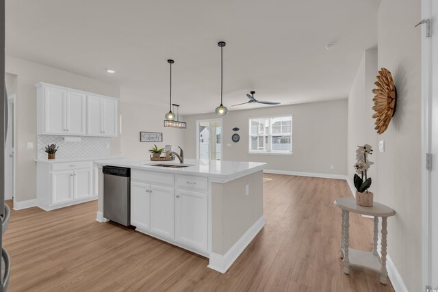 kitchen with dishwasher, a sink, light wood-type flooring, open floor plan, and light countertops