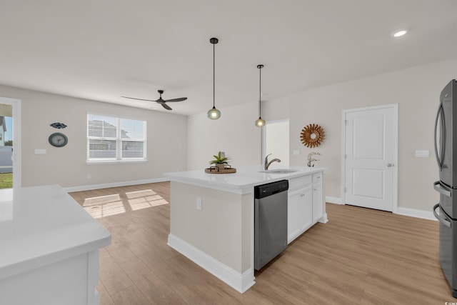 kitchen featuring stainless steel appliances, a sink, a ceiling fan, light wood-style floors, and light countertops
