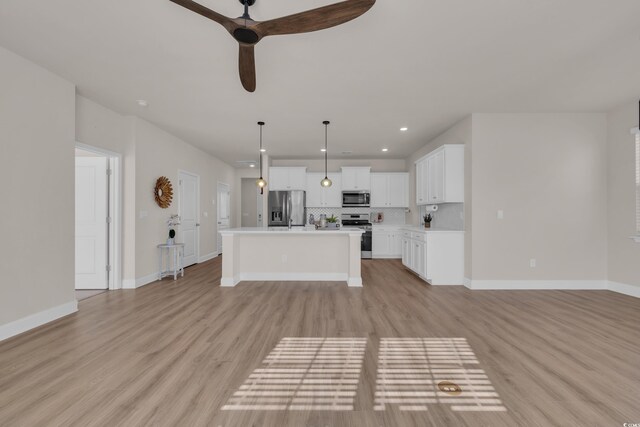 unfurnished living room featuring a ceiling fan, light wood-style floors, baseboards, and recessed lighting
