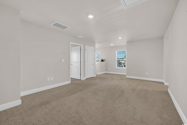 spare room featuring light colored carpet, recessed lighting, and baseboards