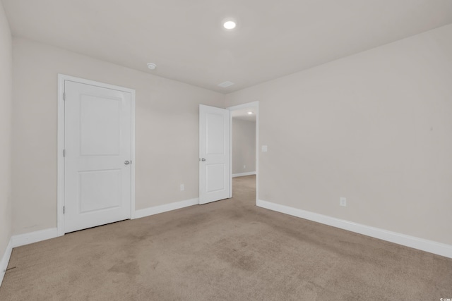 carpeted empty room with baseboards and recessed lighting
