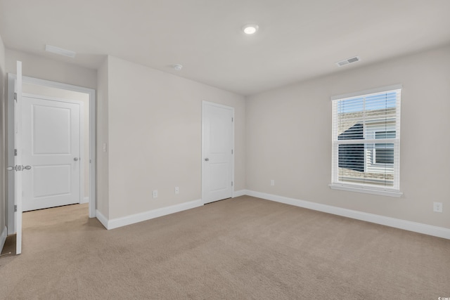 empty room with light carpet and baseboards