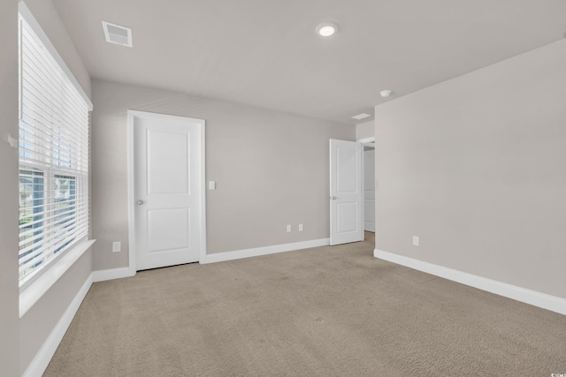 unfurnished bedroom featuring light carpet and baseboards