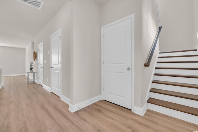 entryway featuring light wood-type flooring, stairs, and baseboards
