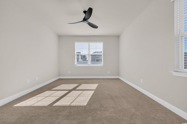 carpeted empty room with a ceiling fan and baseboards
