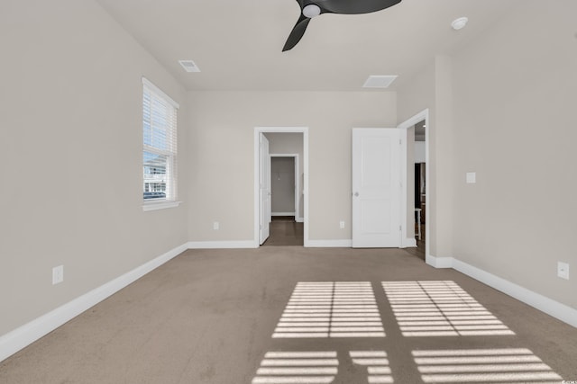 unfurnished bedroom with carpet flooring, baseboards, ceiling fan, and a spacious closet