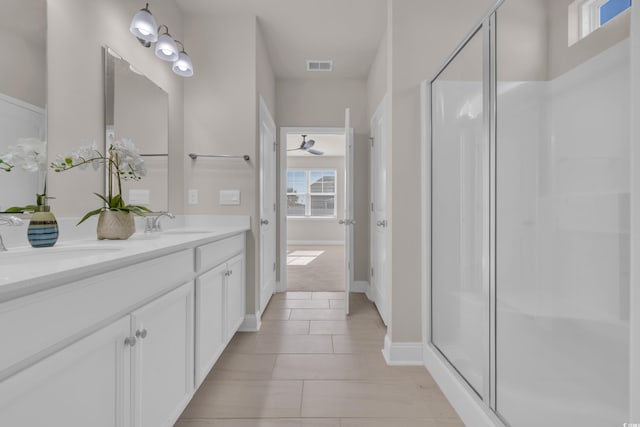 bathroom featuring a shower stall, tile patterned flooring, double vanity, and baseboards