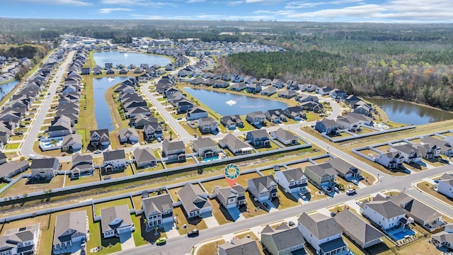 view of property location with nearby suburban area, a heavily wooded area, and a large body of water