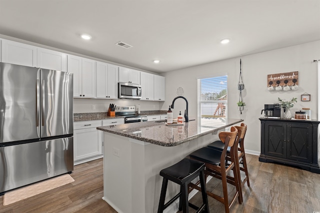 380 Harvest Ridge Way, Conway, SC 29527 - kitchen featuring dark stone countertops, a kitchen breakfast bar, a sink, dark wood finished floors, and appliances with stainless steel finishes