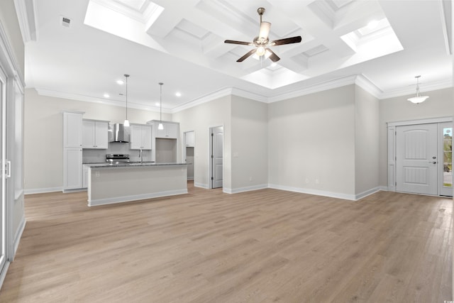 unfurnished living room with recessed lighting, beam ceiling, light wood-type flooring, baseboards, and coffered ceiling