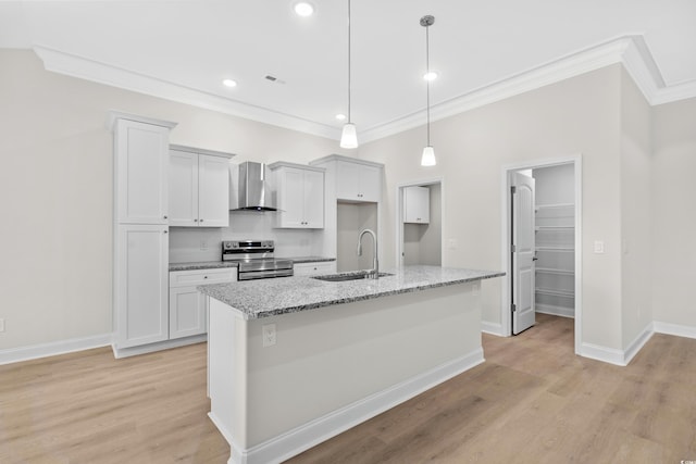 kitchen with a sink, electric range, crown molding, wall chimney range hood, and a center island with sink