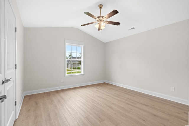 unfurnished bedroom with light wood finished floors, vaulted ceiling, baseboards, and a ceiling fan