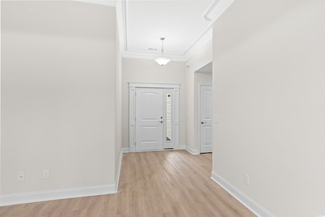 foyer entrance featuring crown molding, light wood-style flooring, and baseboards