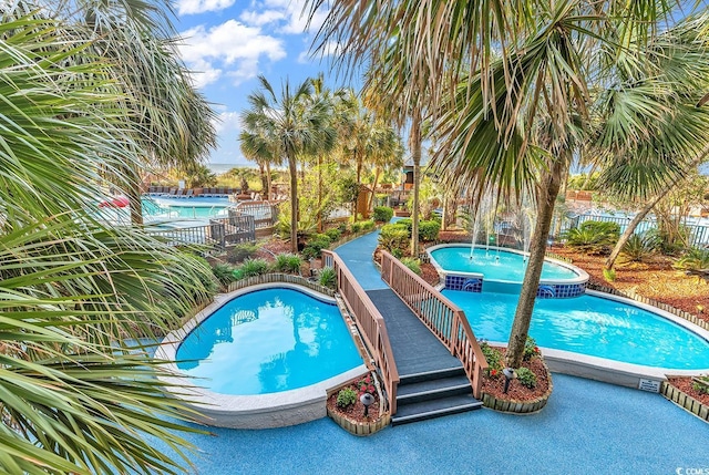 view of pool with a pool with connected hot tub