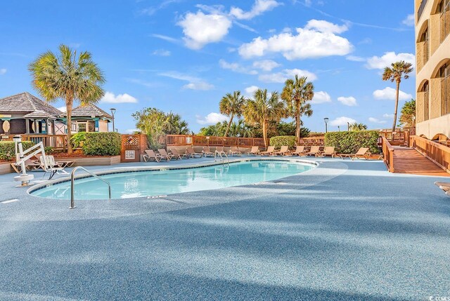 community pool featuring a patio and fence