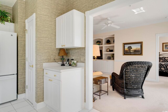 kitchen featuring freestanding refrigerator, a ceiling fan, white cabinets, light countertops, and baseboards