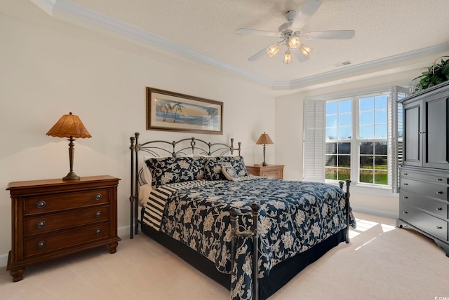 bedroom featuring light carpet, crown molding, baseboards, ceiling fan, and a tray ceiling